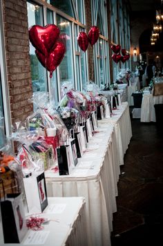 there are many valentine's day items on the tables at this event, including heart shaped balloons