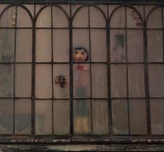 an old window with a doll sticking out of it