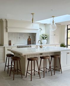 a kitchen with an island and three stools in front of the countertop area