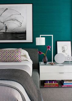 a bedroom with teal walls and pictures on the wall