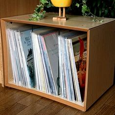 a record player is sitting on top of a wooden shelf with vinyl records in it