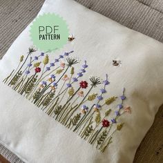 a white pillow with embroidered flowers on it and a green tag that says pdf pattern