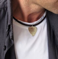 a close up of a person wearing a necklace with a heart shaped pendant on it