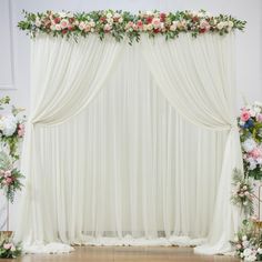 a white drape with flowers and greenery on it