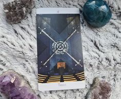 a tarot card sitting on top of a blanket next to some rocks and stones