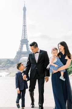 a family walking in front of the eiffel tower with their son and daughter