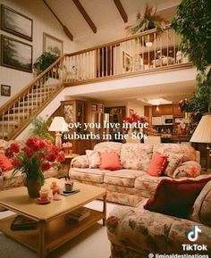 a living room filled with lots of furniture next to a stair case above a coffee table