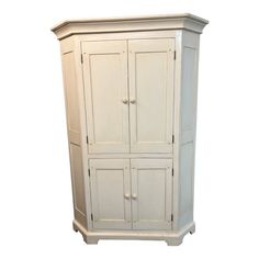 a tall white cabinet with two doors and drawers