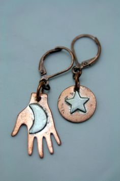 These are very limited but oh so beautiful! Featuring little copper discs, each has a sterling silver charm securely attached. The hand holds the moon, and the disc holds a star. Boho asymmetrical, they are lightweight and super comfortable to wear. Just over 1 1/2 inches from the top of the secure leverback earrings to the bottom of the hand. Funky and Unique  Naturally occurring variations in the finish and color are a characteristic of being HANDMADE. Adjustments made upon request. Drop me a note for a quote on faster shipping, and insurance. Stamped Earrings, Moon And Star Earrings, Company Gifts, Securely Attached, Silver Dangle Earrings, Leverback Earrings, Sterling Silver Dangle Earrings, Silver Earrings Dangle, Mixed Metals