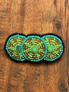 A smaller version of our best-selling barrette, this charming hand-beaded hair accessory measures 1 ¼" in height, 2 ½" in width and has a secure clasp. Beaded in a fun combo of mint, turquoise, black and gold, it has a triple circle design. Measures 1 ¼" in height, 2 ½" in width.   29-117 Adjustable Beaded Hair Accessories For Gifts, Adjustable Beaded Hair Accessories For Gift, Adjustable Beaded Hair Accessories As Gift, Beaded Hair, Amarillo Tx, Hair Beads, Barrette Clip, Circle Design, Hand Beading