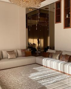 a living room filled with furniture and a chandelier hanging over the top of it