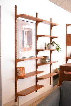 a living room filled with furniture and bookshelves next to a painting on the wall