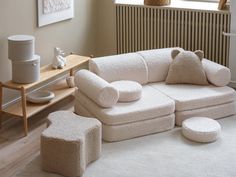 a living room with a white couch, ottoman and coffee table in front of a radiator