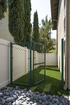 a fenced in area with rocks and grass