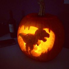 a dinosaur carved into a pumpkin in the dark