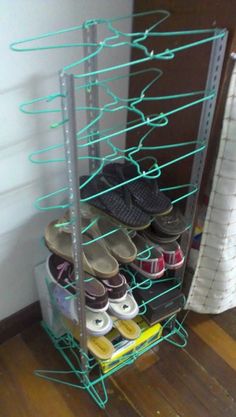 several pairs of shoes are stored on a rack in the corner of a room with wood flooring