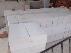 several blocks of white marble stacked on top of each other in a building under construction