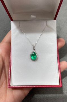 "An absolutely stunning, natural pear Emerald and diamond halo pendant in 14K white gold. The center stone is a Colombian Emerald pear of fine quality, the emerald has incredible green color and very good eye clarity. Any small imperfections are completely normal in natural stones. There are an estimated 1/2ct of high-quality diamonds surrounding the center stone in a delicate halo style. Setting Style: Halo Cluster Setting Material: 18k White Gold / Chain 18\" 18K Main Stone: Emerald Shape: Pea Pear-shaped Emerald Necklace In White Gold For Wedding, Pear-shaped White Gold Emerald Necklace For Wedding, Green Diamond Drop Necklaces, Fine Jewelry Emerald Pear-shaped Necklace, Fine Jewelry Emerald Teardrop Diamond Necklace, Pear-shaped Emerald Necklace For Wedding, Fine Jewelry Emerald Necklace With Pear Gemstone, Pear-shaped Emerald Necklace In Fine Jewelry Style, Teardrop Emerald And Diamond Necklace