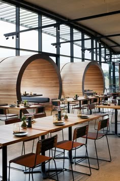 an empty restaurant with tables and chairs in front of large windows that have wooden slats on them