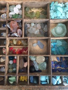 an old wooden box filled with lots of different colored rocks and stones in it's compartments