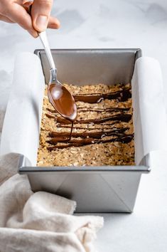 a person spooning some food out of a pan with oatmeal and chocolate