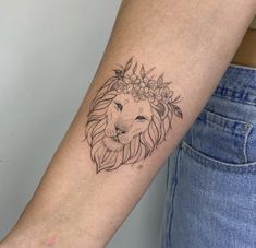 a woman's arm with a lion tattoo on the left side of her arm