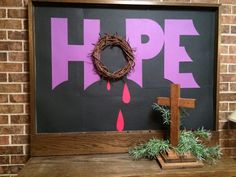 a wooden cross sitting on top of a table next to a sign that says hope