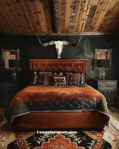 a bed room with a neatly made bed and a cow skull on the wall