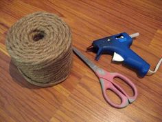 a spool of twine and scissors are on the floor next to a roll of twine