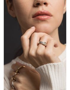 a woman wearing a gold ring and white sweater