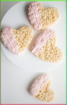 three heart shaped cookies sitting on top of a white plate