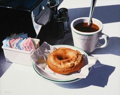 a donut sitting on top of a plate next to a cup of coffee