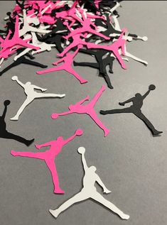 pink and black air jordan cutouts on a gray surface with one person in the middle