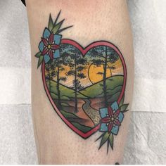 a heart shaped tattoo with trees and flowers on it