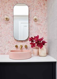 a bathroom with a pink sink and mirror