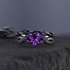 a purple heart shaped ring with two skulls on it