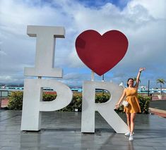 a woman posing in front of the i love pr sign