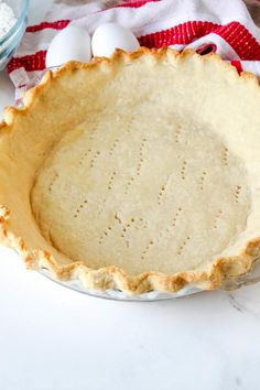 an uncooked pie crust in a bowl with eggs on the side and text overlay that reads homemade pie crust recipe