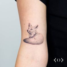 a small fox tattoo on the arm