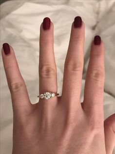 a woman's hand with a three stone ring on top of her left hand