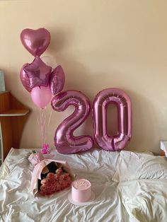 the balloons are in the shape of numbers on the bed, and there is a bouquet of flowers next to it