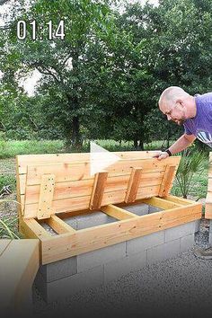 an older man is placing plants in the planter boxes on top of a bench