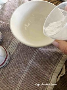 someone is pouring milk into a bowl on top of a table next to baseballs