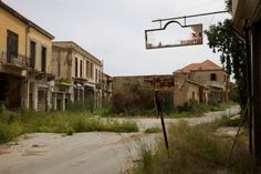 an old run down street with lots of buildings in the background