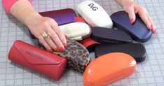 a woman's hand is touching several different colored shoes