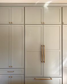 an empty kitchen with white cabinets and gold pulls on the door knobs that are brass