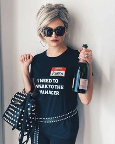 a woman with sunglasses holding a bottle of wine and wearing a t - shirt that says i need to speak to the manager