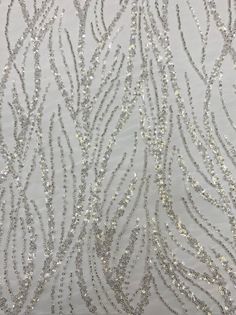 silver sequins on white fabric with wavy lines in the center and small beads at the bottom