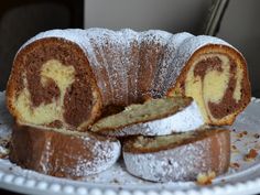 a bundt cake on a white plate with powdered sugar and chocolate swirls