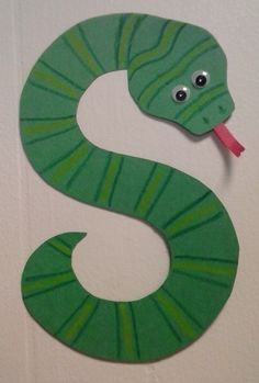 a paper snake with tongue sticking out of it's mouth on a white wall